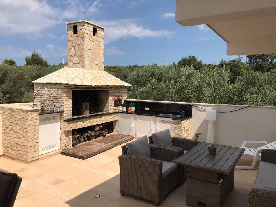 Loungebereich mit Grillkamin auf der Terrasse
