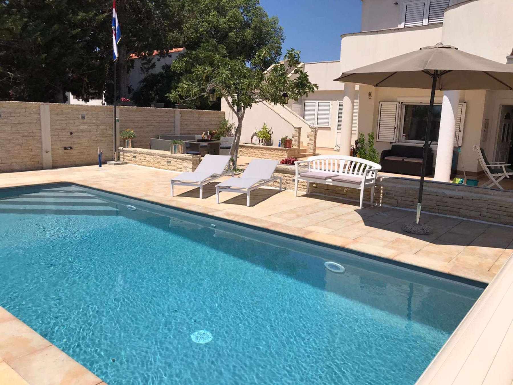 Pool des Ferienhauses mit Sonnenliegen